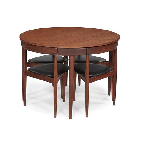 A round wooden dining table with four matching nesting chairs featuring dark cushioned seats, shown on a plain white background.