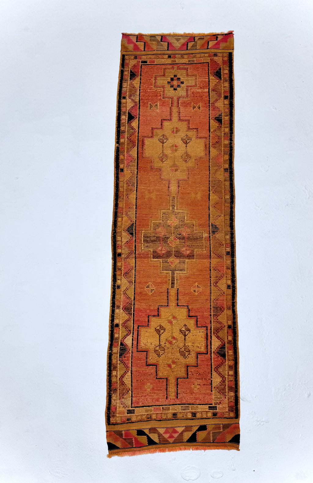Long rectangular rug with geometric pattern on a white background