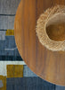 Wooden table with a straw hat on a patterned rug