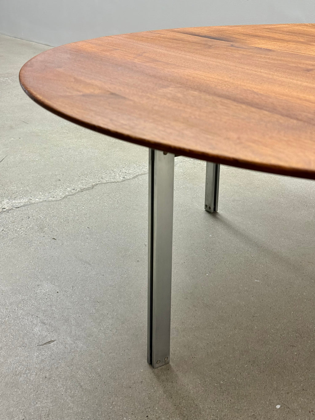 Wooden table with metal legs on a concrete floor