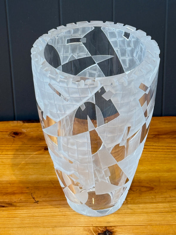 Decorative glass vase with etched design on a wooden surface