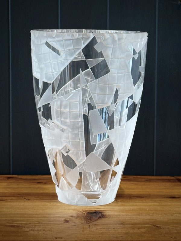 Decorative glass vase with geometric pattern on a wooden surface