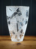 Decorative glass vase with geometric pattern on a wooden surface