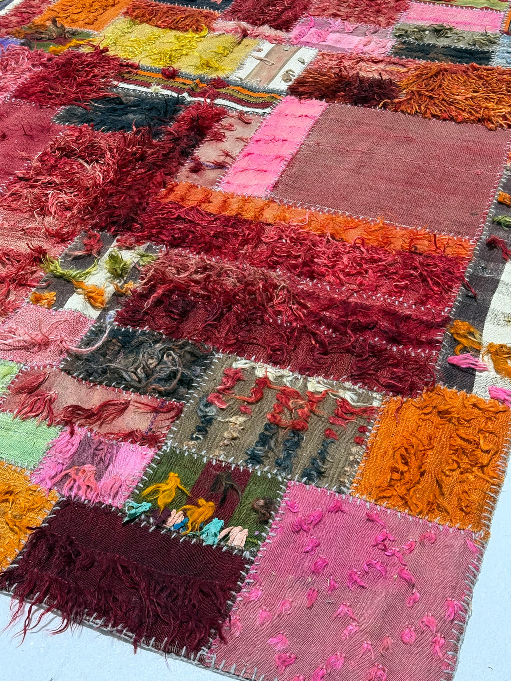 Patchwork rug with multicolored squares and textured patterns