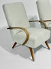 Light gray armchair with wooden armrests and legs on a white background