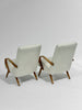 Two beige armchairs with wooden arms and legs on a white background