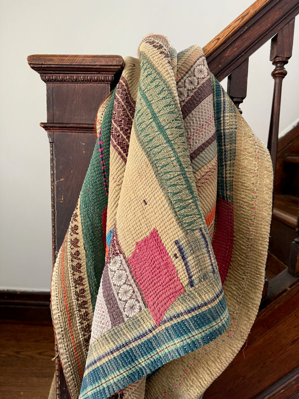 Multicolored woven blanket draped over a wooden staircase