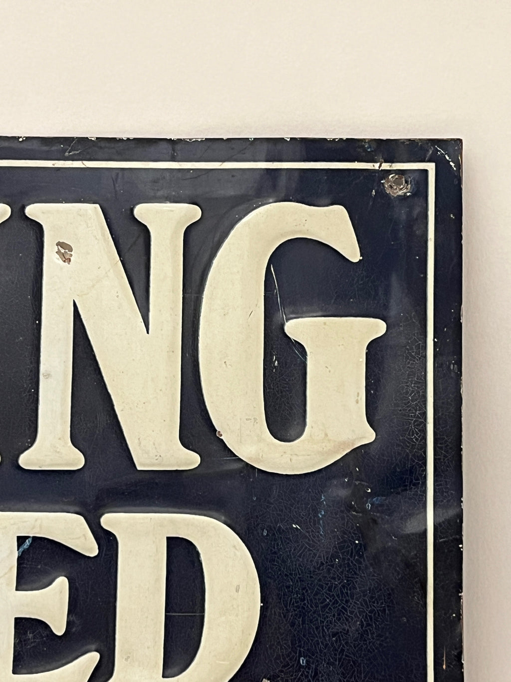 Close-up of a sign with partially visible text on a white background
