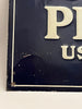 Vintage-style sign with branding on a dark background