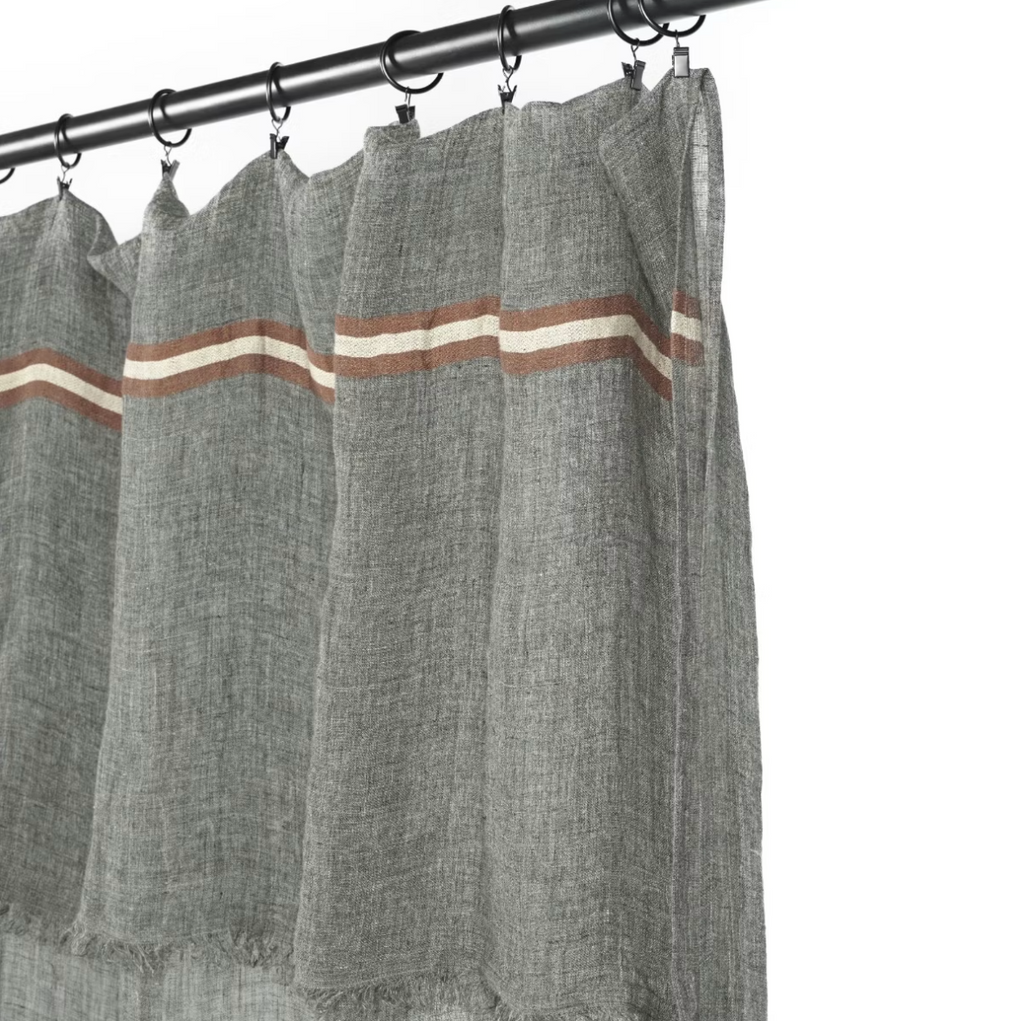 Gray curtains with brown and white stripes hanging on a rod against a white background