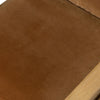 Close-up of a brown textured cushion with a wooden edge.