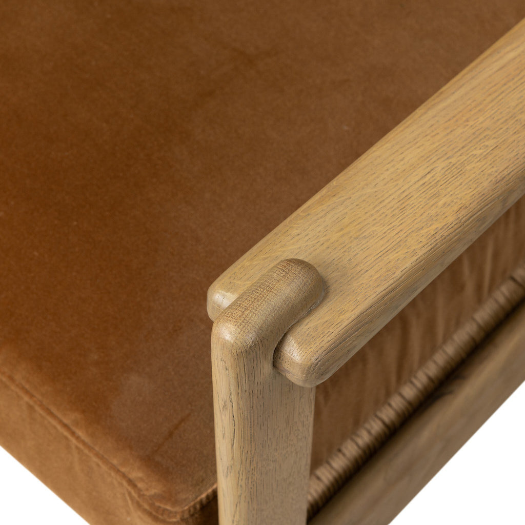 Brown upholstered chair with wooden armrest on a white background
