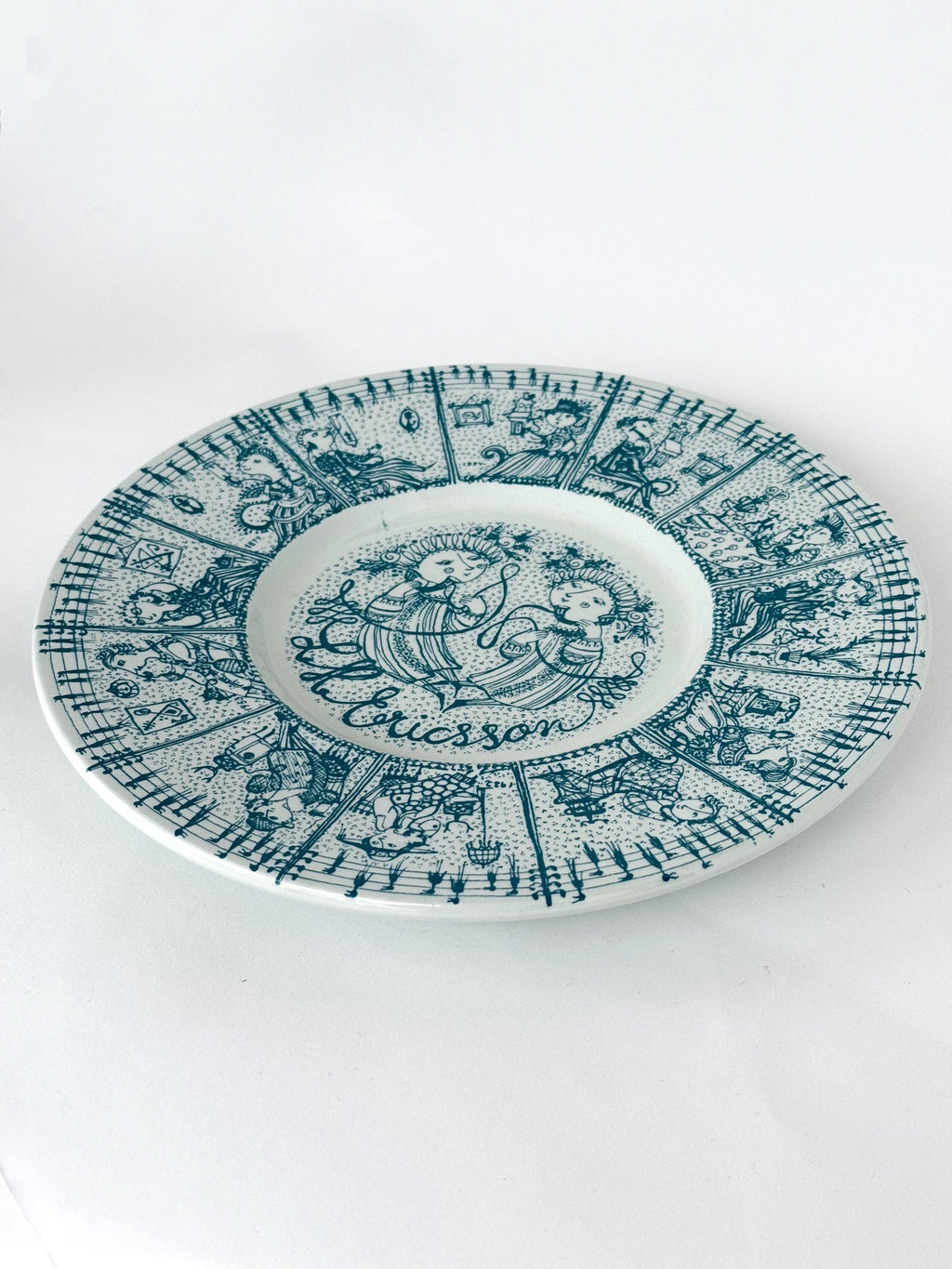 Decorative plate with intricate blue patterns and 'La Coccinelle' branding on a white background