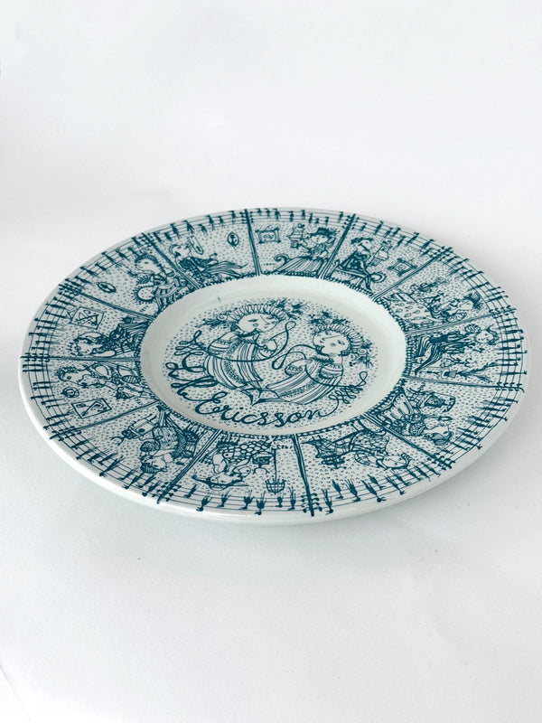 Decorative plate with intricate blue patterns and 'La Coccinelle' branding on a white background