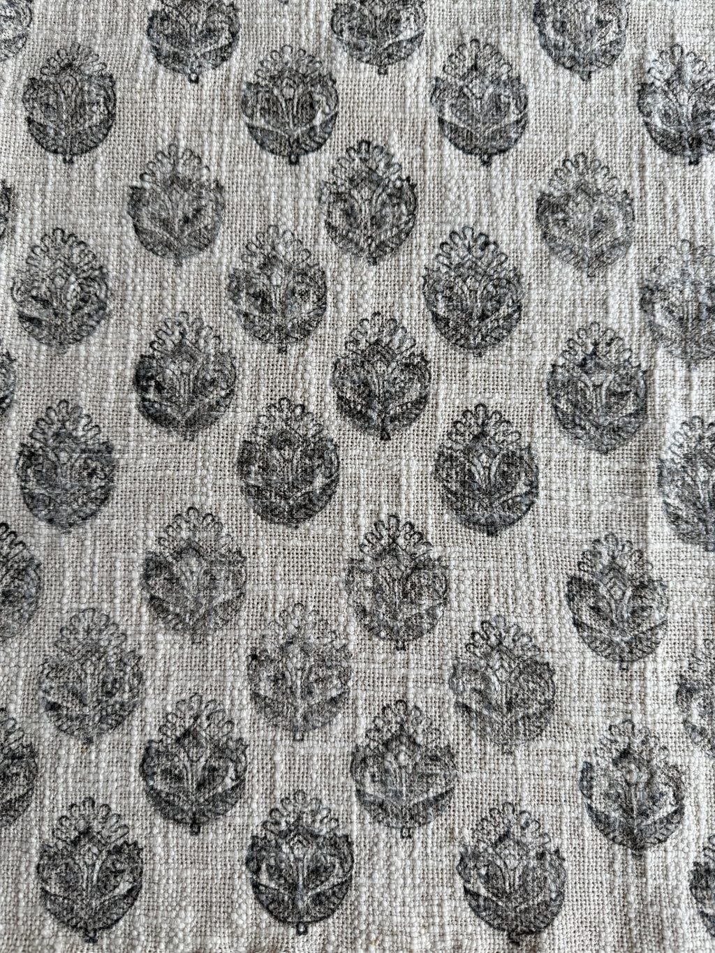 Textile pattern with black floral shapes on a light background