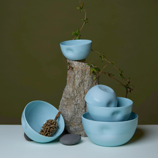 blue ceramic bowls on a wooden stump with a minimal background middle kingdom pottery