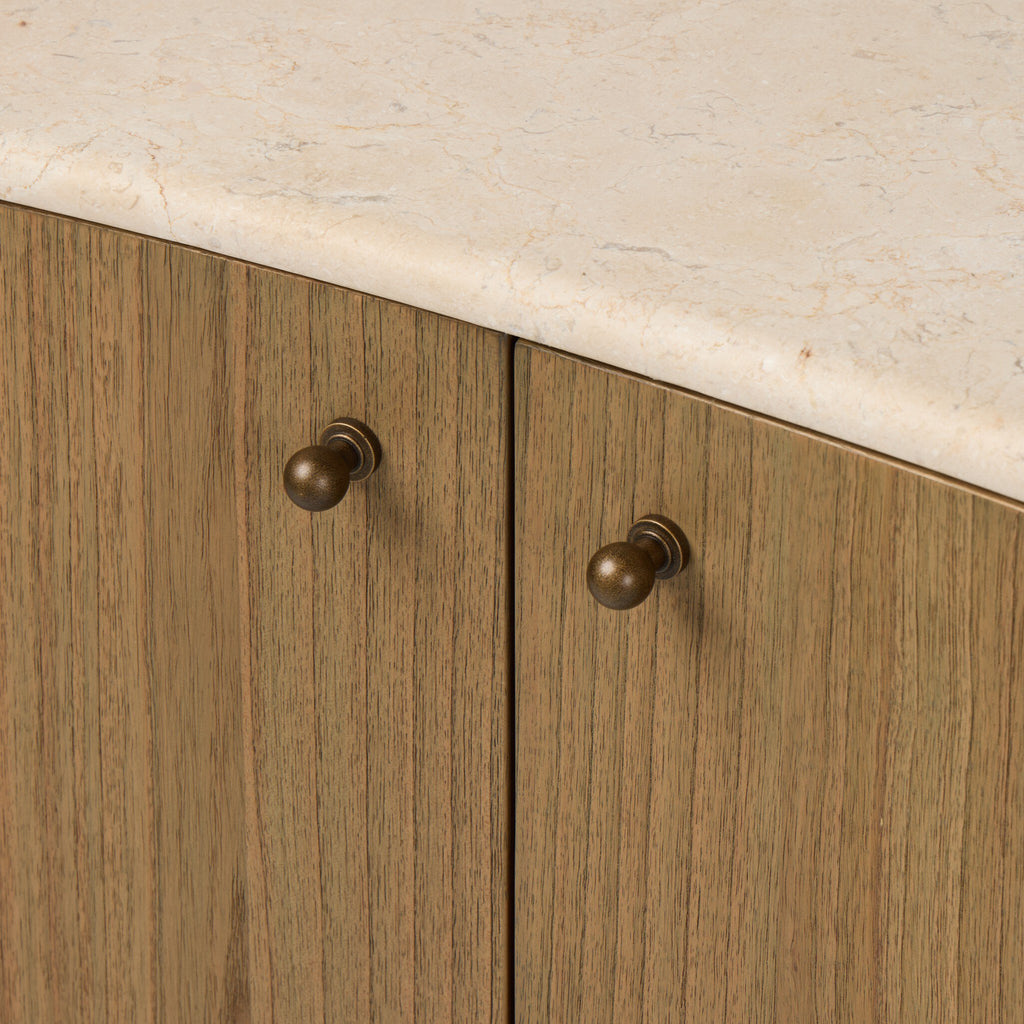 Wooden cabinet doors with bronze handles on a light-colored countertop.