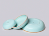 Three light blue ceramic bowls with gold rims on a gray background