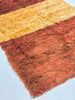 Close-up of a textured rug with brown and beige colors on a light blue background