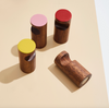 Four magnetic wooden pegs with colorful tops on a beige background