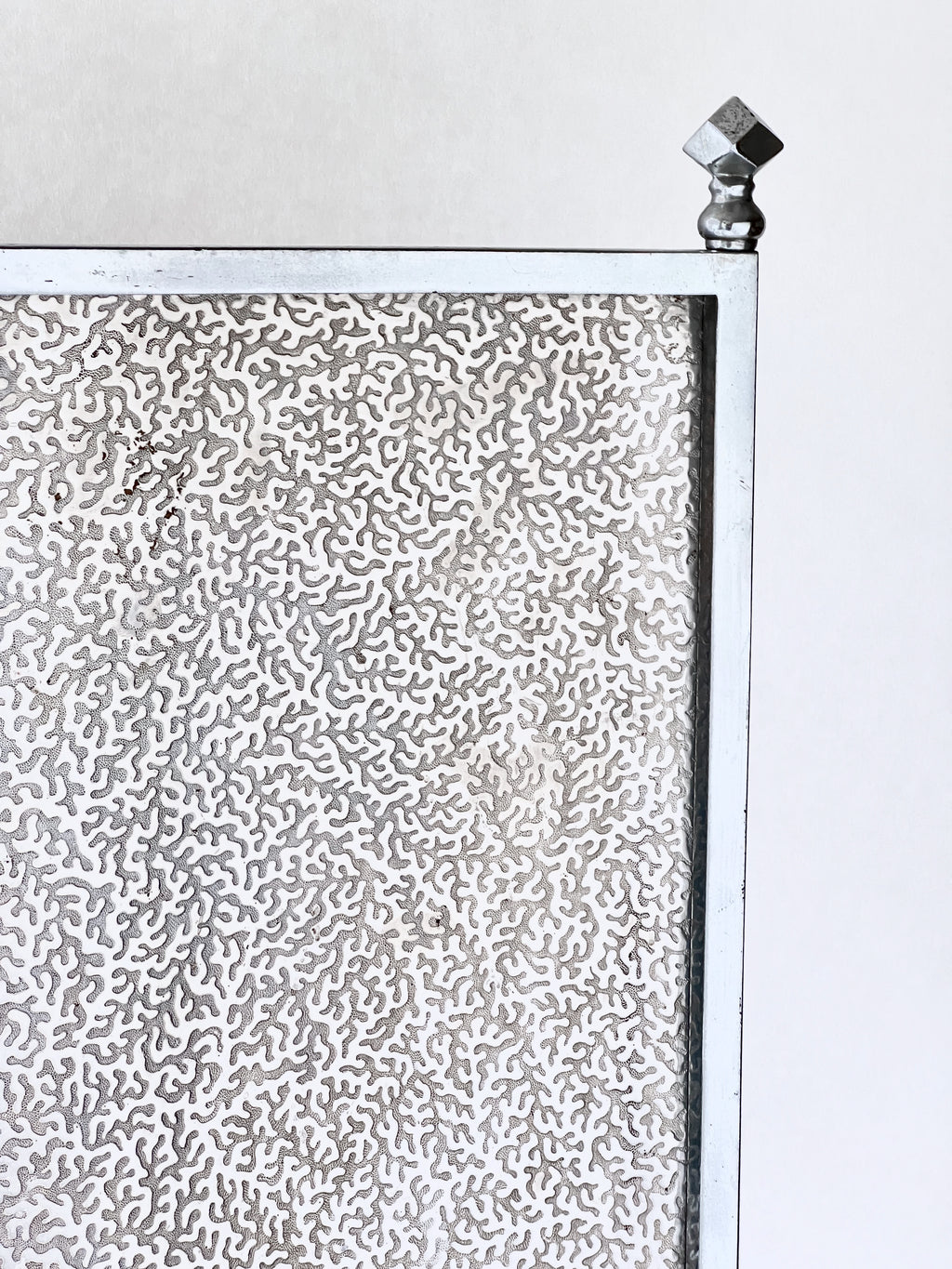 Metallic textured panel with a geometric design on a white background