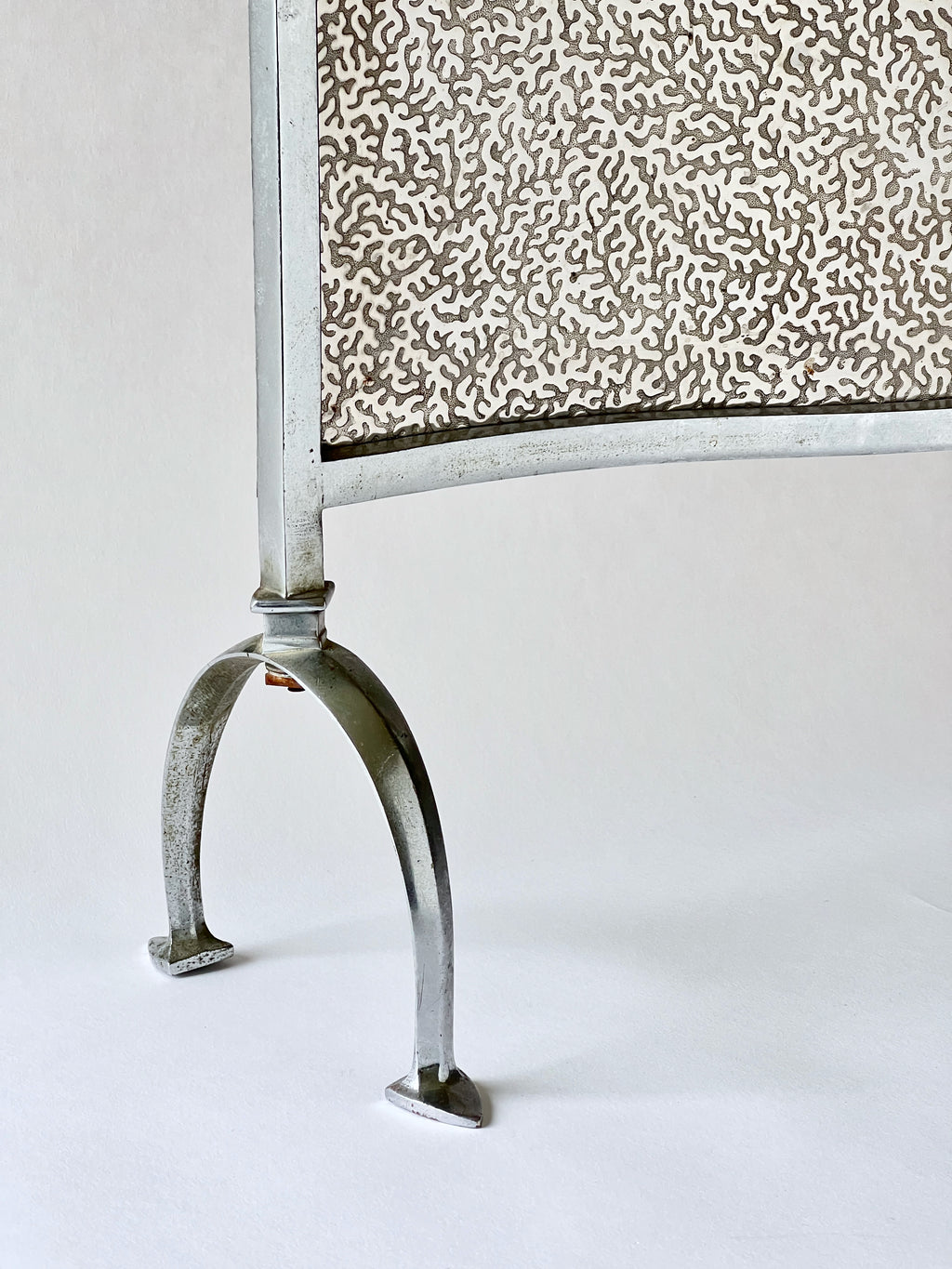 Metal fire screen with decorative pattern on a white background