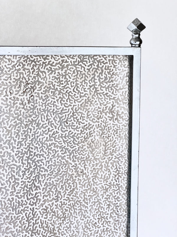 Metallic textured panel with a geometric design on a white background