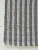 Striped gray and white rug on a light wooden floor