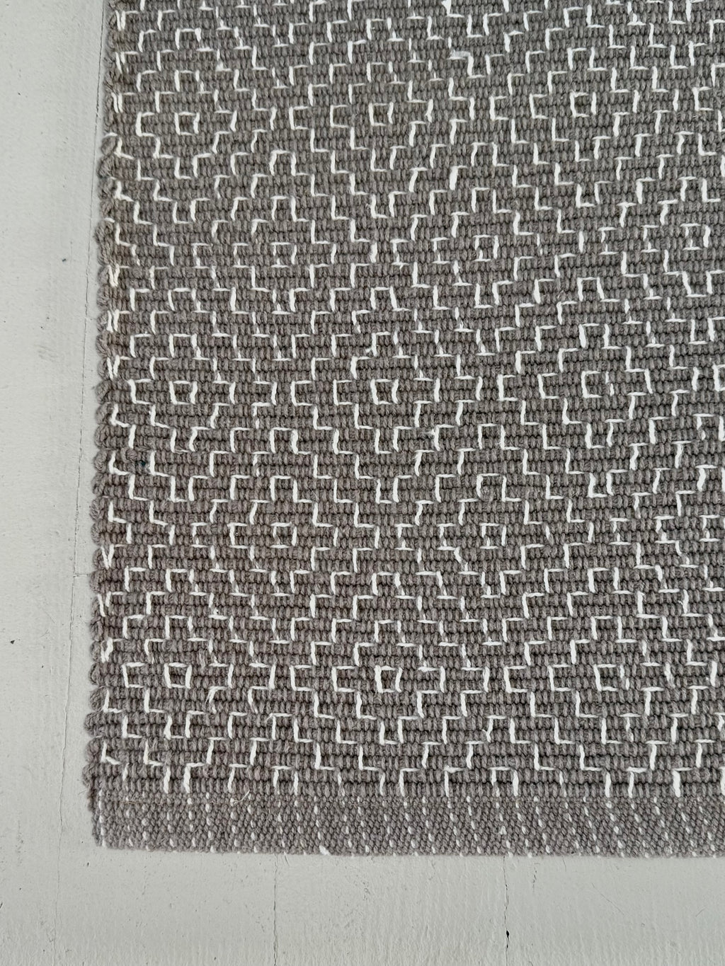 Textured gray and white patterned fabric on a plain background
