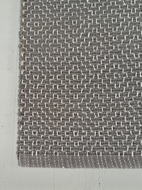 Textured gray and white patterned fabric on a plain background