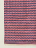 Striped pink and purple rug on a white background