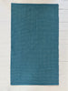 Blue patterned cotton woven rug on a white wooden floor