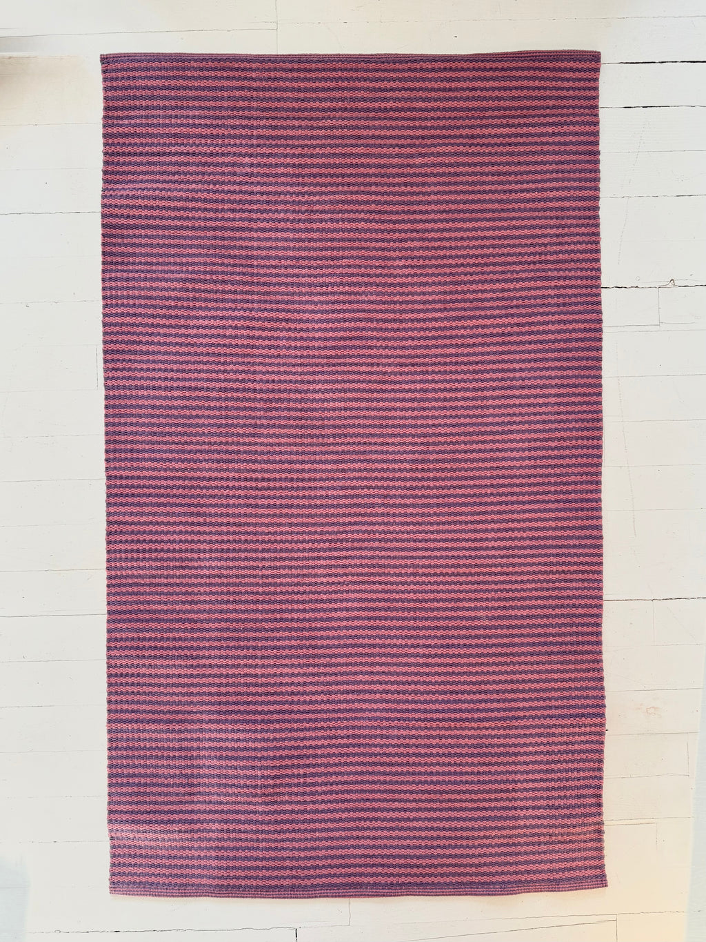 Purple striped rug on a light wooden floor