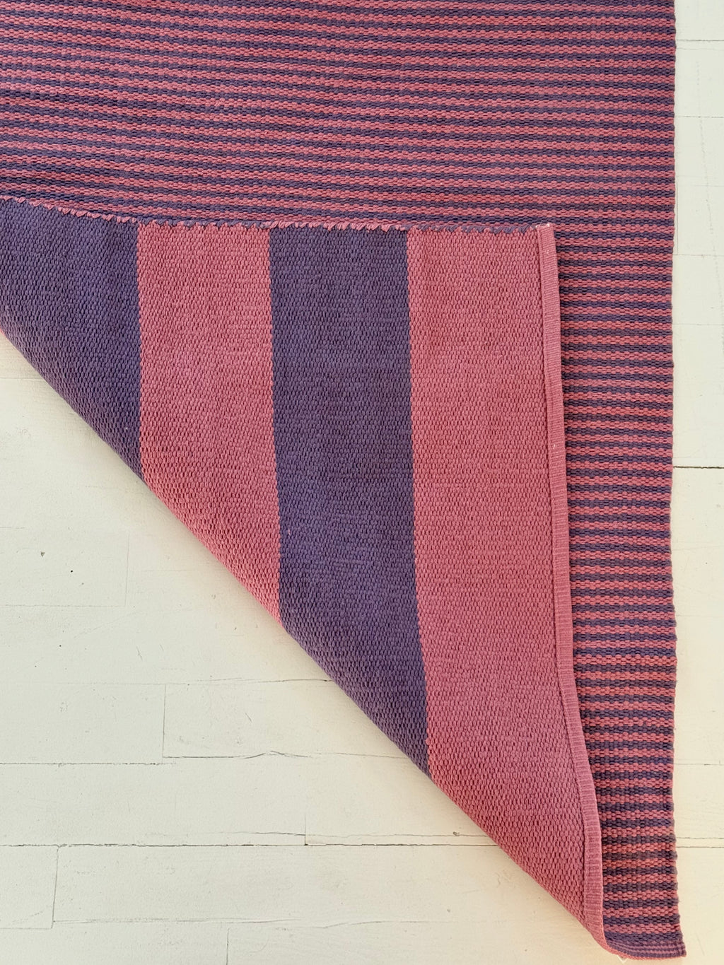 Striped fabric with purple and pink pattern on a white background
