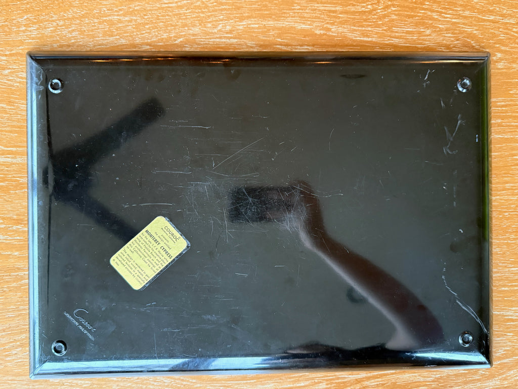 Scratched black surface with a yellow label on a wooden background