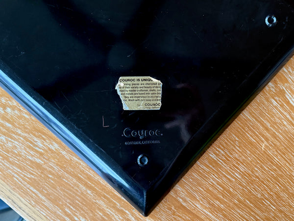 Black tray with a visible brand logo couroc on a wooden surface