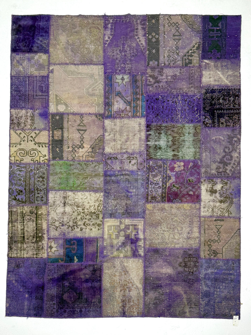 Patchwork rug with a mix of purple, blue, and gray colors on a white background