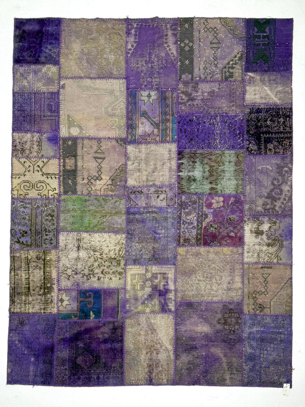 Patchwork rug with a mix of purple, blue, and gray colors on a white background