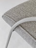 Close-up of a textured gray cushion on a white chair with a white background