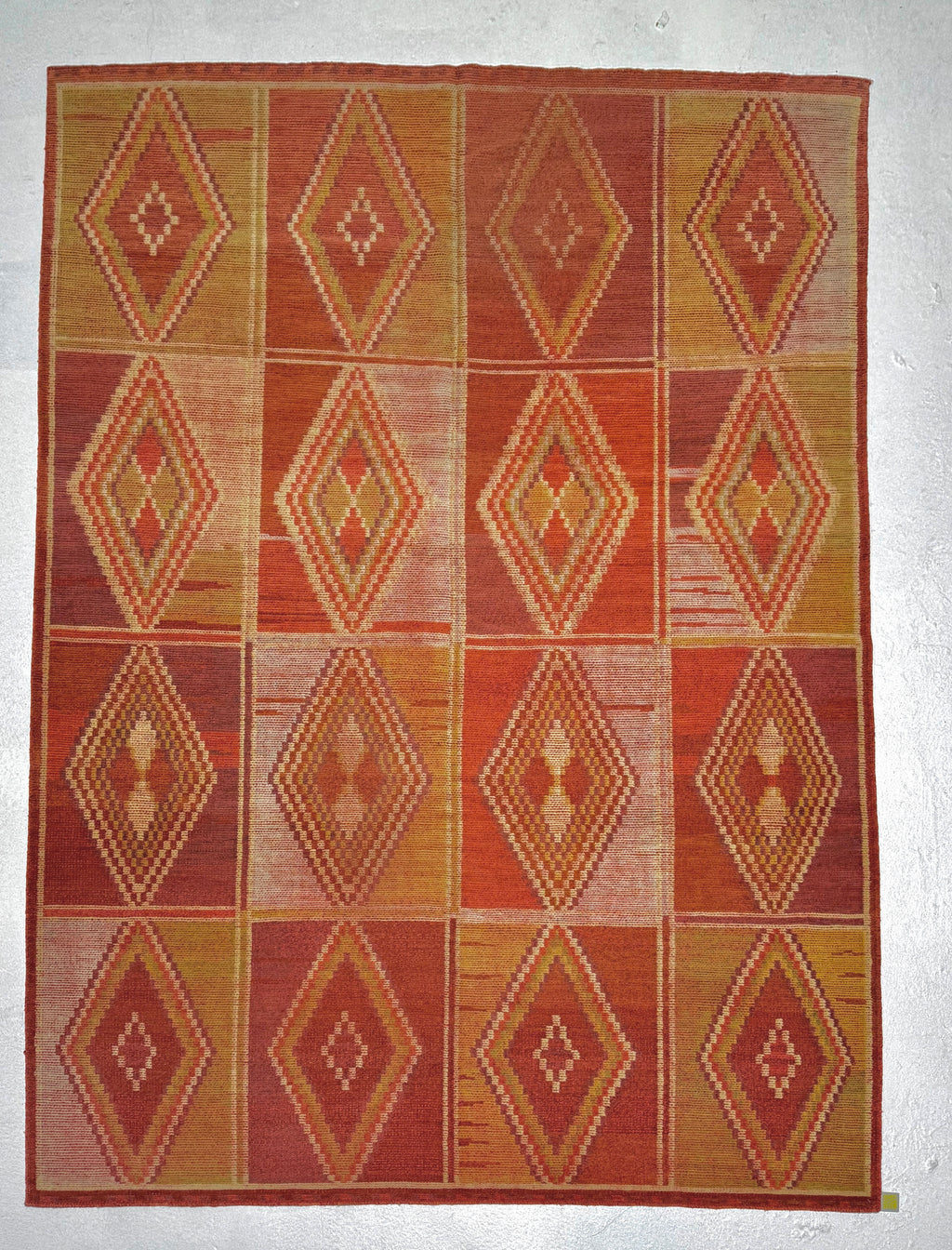 Rug with diamond pattern in red and brown on a white background