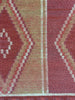 Close-up of a patterned rug with red and beige colors