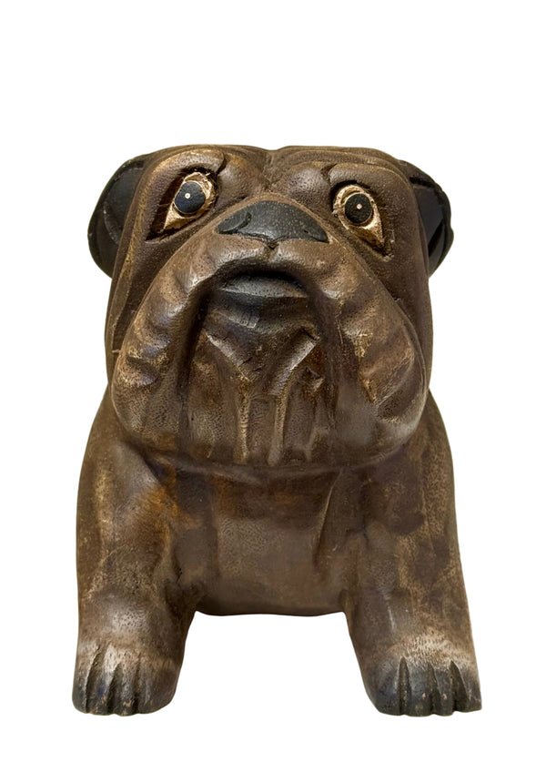 wood bulldog sculpture on a white surface with a beige background