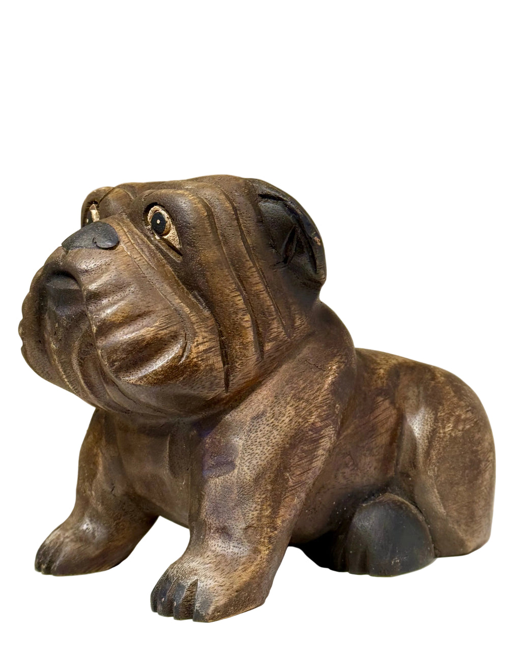 Wooden sculpture of a bulldog on a white surface with a beige background