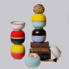Stacked porcelain ceramic bowls in various colors on a light gray background