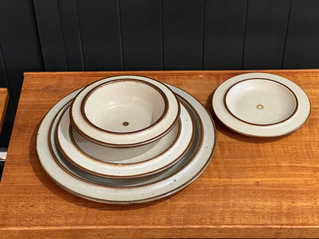 Set of ceramic bowls on a wooden surface with a dark panel background