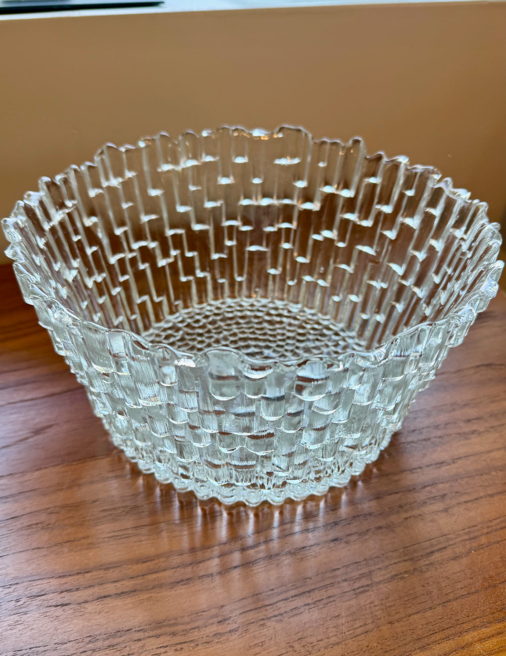 Clear glass bowl with textured design on a wooden surface
