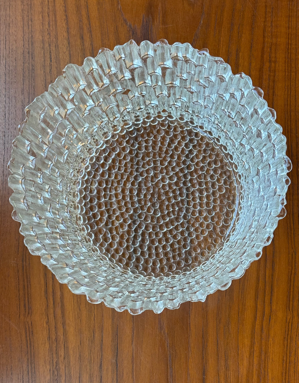 Clear glass plate with textured design on a wooden surface