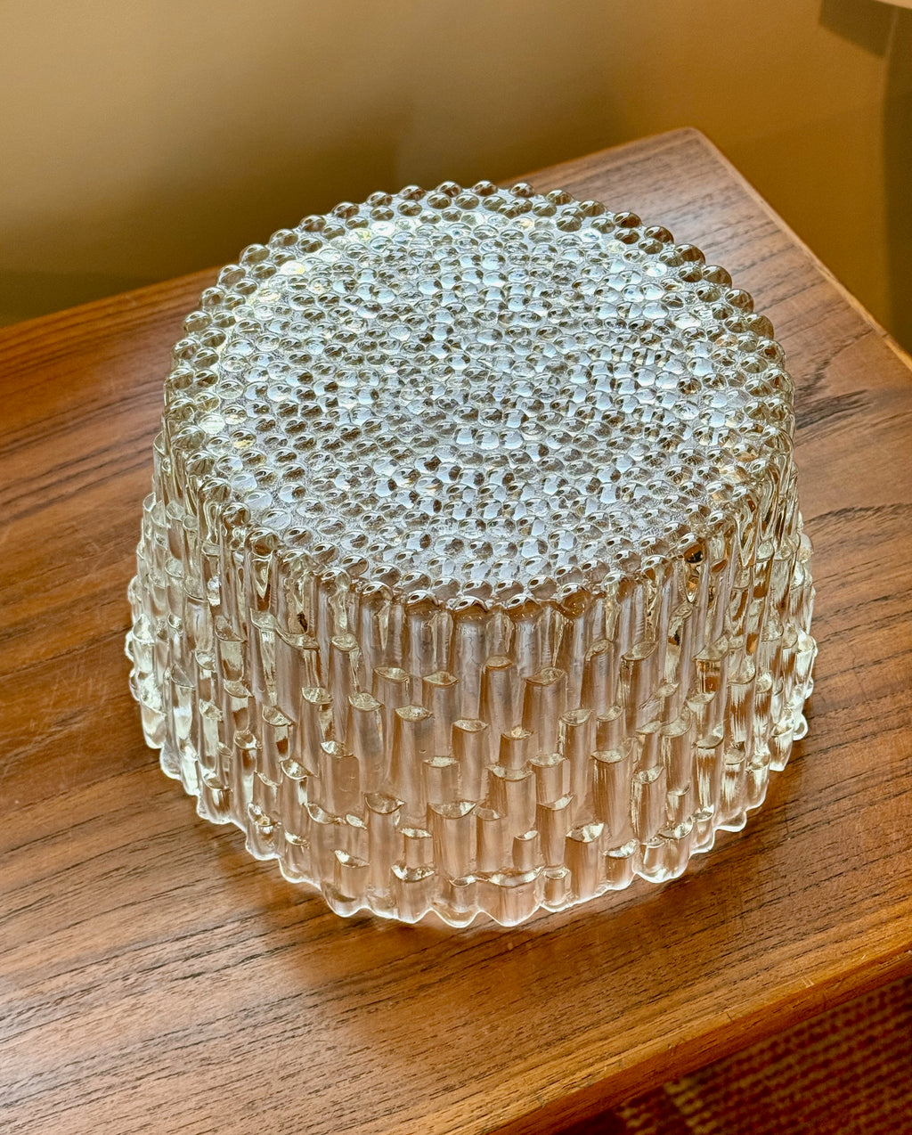 Clear glass bowl container with textured surface on a wooden surface