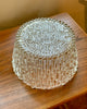 Clear glass bowl container with textured surface on a wooden surface