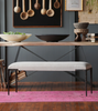 Dining room with wooden table, gray bench, and decorative items on a dark gray wall.